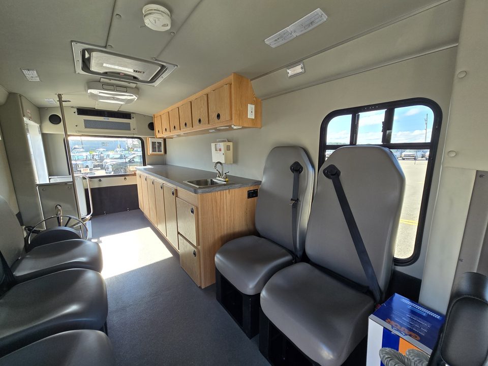 Outreach unit interior: forward-facing seats and counter with sink