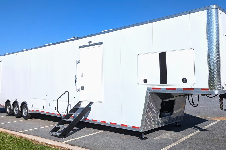 White triple-axle gooseneck trailer, front three-quarter