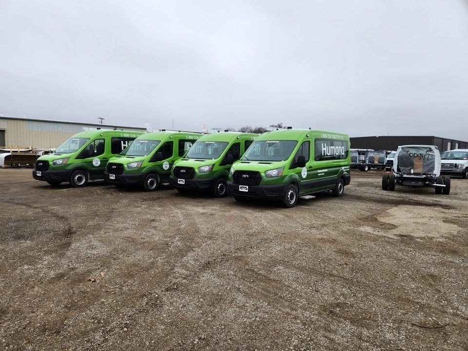 A row of wrapped Ford Transit vans outside the HLE plant