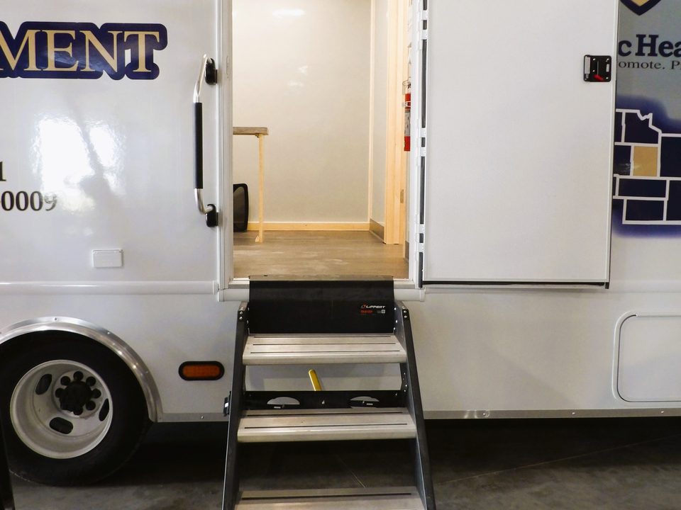 Curbside entry door open with fold-down steps on the mobile clinic