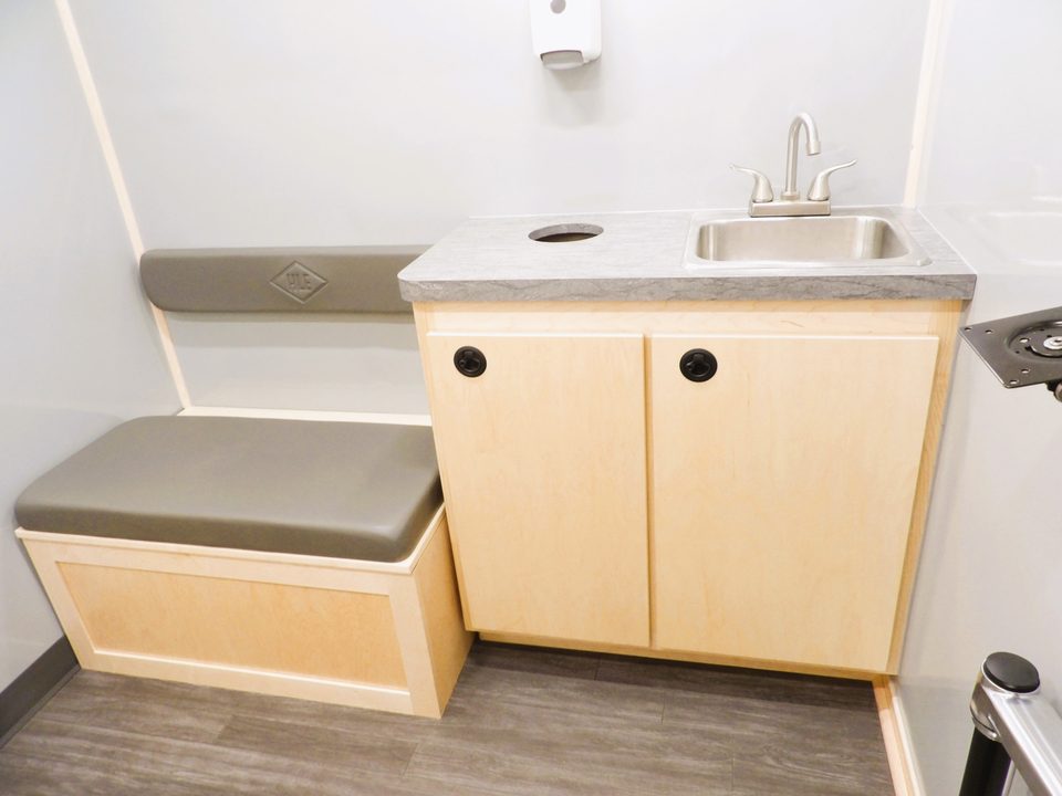 Clinic interior: sink counter, cabinet and padded bench seat
